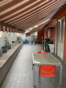 a patio with a table and two red chairs at La Terrazza in San Giovanni Valdarno