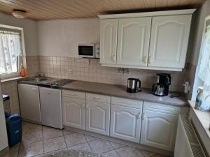 a kitchen with white cabinets and a counter top at Ferienhaus Gampe in Klingenthal