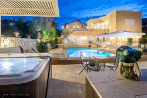 a pool with a table and chairs next to a building at Villar in Rosh Pinna