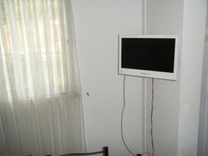 a flat screen tv on a wall next to a window at Casa da Costureira in Olival