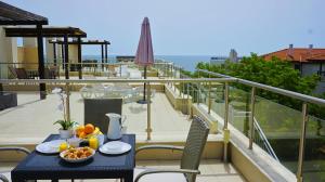 a table with a bowl of fruit on a balcony at Бяла Виста Клиф - Byala Vista Cliff in Byala