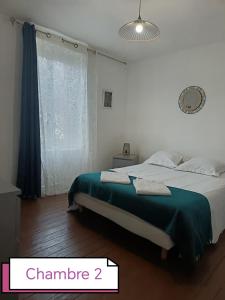 a bedroom with a bed with a green blanket at Maison Gambetta in Ouistreham