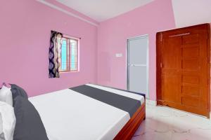 Un dormitorio con una cama y una puerta de madera. en Hotel O S Hotel & Restaurant, en Patna