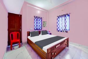 Un dormitorio con una cama y una silla roja. en Hotel O S Hotel & Restaurant, en Patna