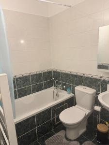a bathroom with a toilet and a tub and a sink at Close to Paris & Disney & Ofpra in Le Perreux-Sur-Marne