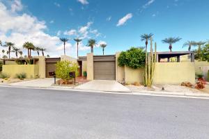 a house with palm trees in front of a street at Palm Oasis Escape in Palm Springs