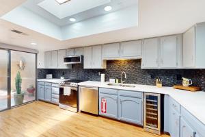 a large kitchen with white cabinets and wood floors at Palm Oasis Escape in Palm Springs
