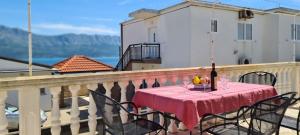 a table with a pink table cloth on a balcony at House Karmela in Sućuraj