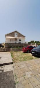 a house with two cars parked in front of it at House Karmela in Sućuraj
