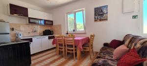 a kitchen and living room with a table and a couch at House Karmela in Sućuraj