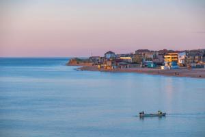 two people in a boat in the water near a beach at Casa din Vamă in Vama Veche