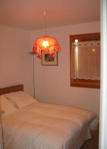 a bedroom with a bed and a lamp and a window at Chalet de l'Orceyrette, idéal pour un couple ou famille avec 2 enfants in Briançon
