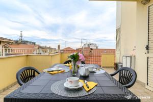 - une table sur un balcon avec une table et des chaises dans l'établissement Quadrilocale Piave - InVacanza, à Alba Adriatica