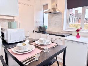 a kitchen with a table with plates and wine glasses at Great Studio 30min to Central London in London
