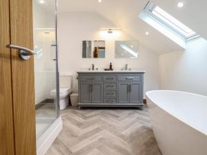 a bathroom with a sink and a tub and a toilet at Gaerau Bach in Llanbedr +26 photos