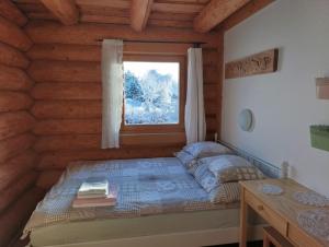 Un dormitorio con una cama en una cabaña de troncos en Srub Javorná - apartmány Šumava, en Javorná