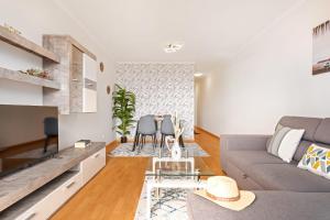 una sala de estar con un sofá y una mesa en Sunflower Living by Homie, en Caniço