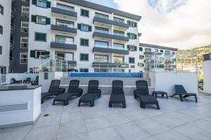 un grupo de sillas sentadas en un patio frente a un edificio en Sunflower Living by Homie, en Caniço