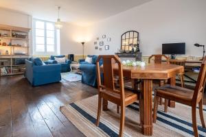 a living room with a table and chairs and a couch at Charming house Le Clos Marie in Châteaubourg