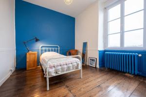 a bedroom with blue walls and a bed in it at Charming house Le Clos Marie in Châteaubourg