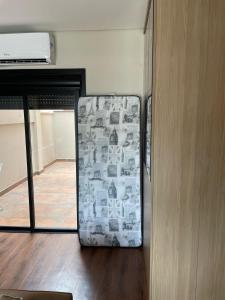 a refrigerator sitting on the floor next to a door at Studio Central Todo Planejado com Ar Condicionado in Bagé