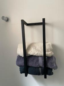 a towel rack with towels on a wall at Studio Central Todo Planejado com Ar Condicionado in Bagé