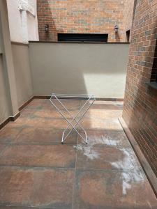 a metal chair sitting on a floor next to a brick wall at Studio Central Todo Planejado com Ar Condicionado in Bagé