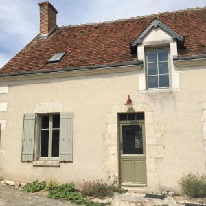a white house with two windows and a door at La Saulainière in Pontlevoy