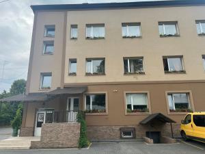 ein Gebäude, vor dem ein gelber Lieferwagen parkte in der Unterkunft PETROVICH hotel in Chust