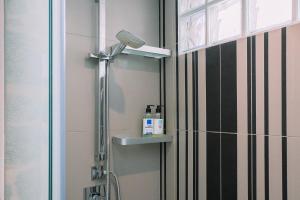 a shower in a bathroom next to a door at A 5 min de las Playas de Cangas by CABANA Rentals in Cangas de Morrazo +19 photos