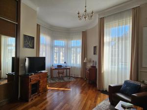 a living room with a television and a couch at Margaret Buda Apartman city view in Budapest