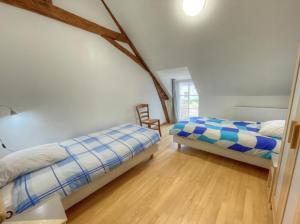 a bedroom with two beds and a wooden floor at La Saulainière in Pontlevoy