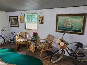 a room with a bicycle and chairs and a painting of a ship at Your second home in florida in Altoona