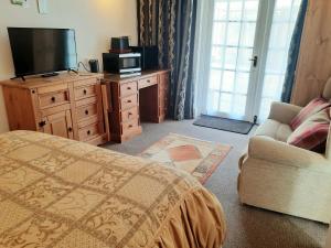 Televiisor ja/või meelelahutuskeskus majutusasutuses Double Ensuite with Bath, Sofa, Desk, Wardrobe