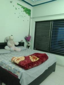 a bed with a teddy bear sitting on top of it at 2 Room set floor in Mathura