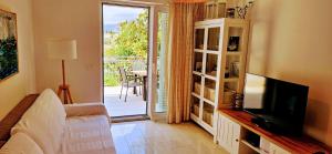 a living room with a television and a door to a patio at Villa Pepo in Cavtat