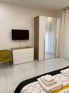a room with a television and a bed with towels at Nicola's Apartments in Santa Maria La Carità