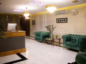 a waiting room with two green chairs and a table at AGATS hotel in Atyrau