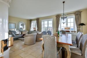 un salon avec une table, des chaises et un canapé dans l'établissement Godewind Haus Godewind, GO01, à Rantum