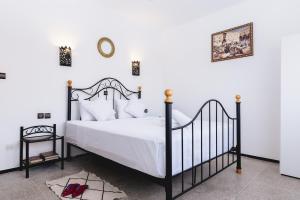 una camera con un letto bianco e nero e una sedia di Cosy Studio a Marrakech