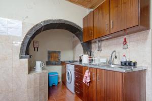 a kitchen with a sink and a washing machine at A Casa d'Amália in Ginetes