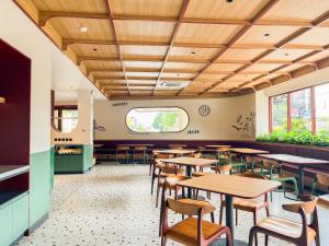 un ristorante con soffitti in legno, tavoli e sedie di Kotta GO Hotel Tegal a Tegal