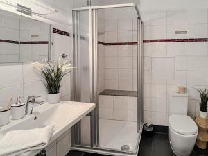 a bathroom with a shower and a sink and a toilet at FeWo Schiffsblick - Horumersiel in Horumersiel +16 photos
