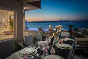 a table with wine glasses and flowers on it at La Villa - BEACHFRONT - INFINITY HEATED POOL - NEW in Sutivan