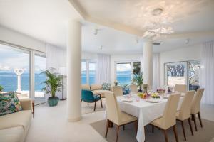 a white dining room with a table and chairs at La Villa - BEACHFRONT - INFINITY HEATED POOL - NEW in Sutivan +78 photos