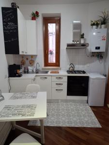a kitchen with white cabinets and a stove top oven at Da Zia Lù in Tivoli