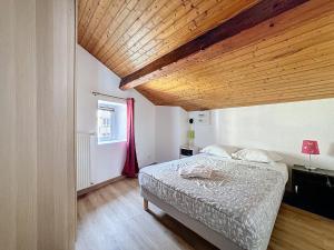 a bedroom with a bed with a wooden ceiling at F3 refait à neuf en centre ville Liberation in Clermont-Ferrand