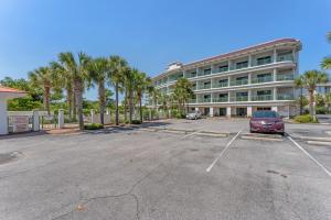 a car parked in a parking lot in front of a building at Inn at Seacrest 309- Somewhere in the Sun in Inlet Beach