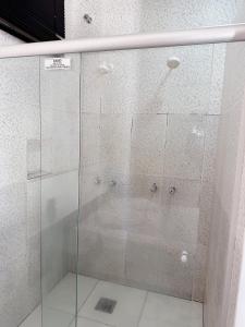 a shower with a glass door in a bathroom at Motel Wish in Campinas