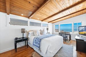a bedroom with a bed and a desk and a television at Luxurious Seaside Escape-150 Steps to the Beach-Panoramic Ocean Views in Laguna Beach